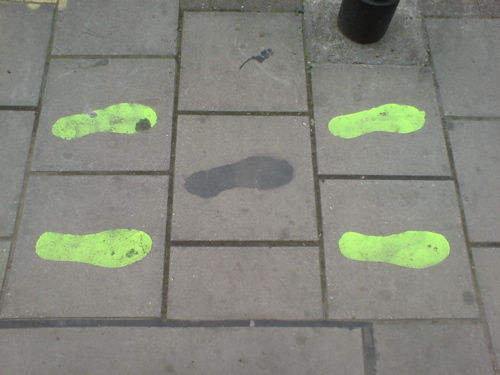 yellow footprints on a sidewalk - Brick lane